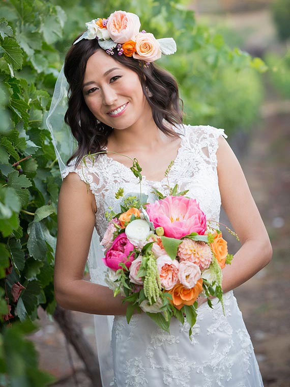 Bride next to grapevine at a vinery in Temecula